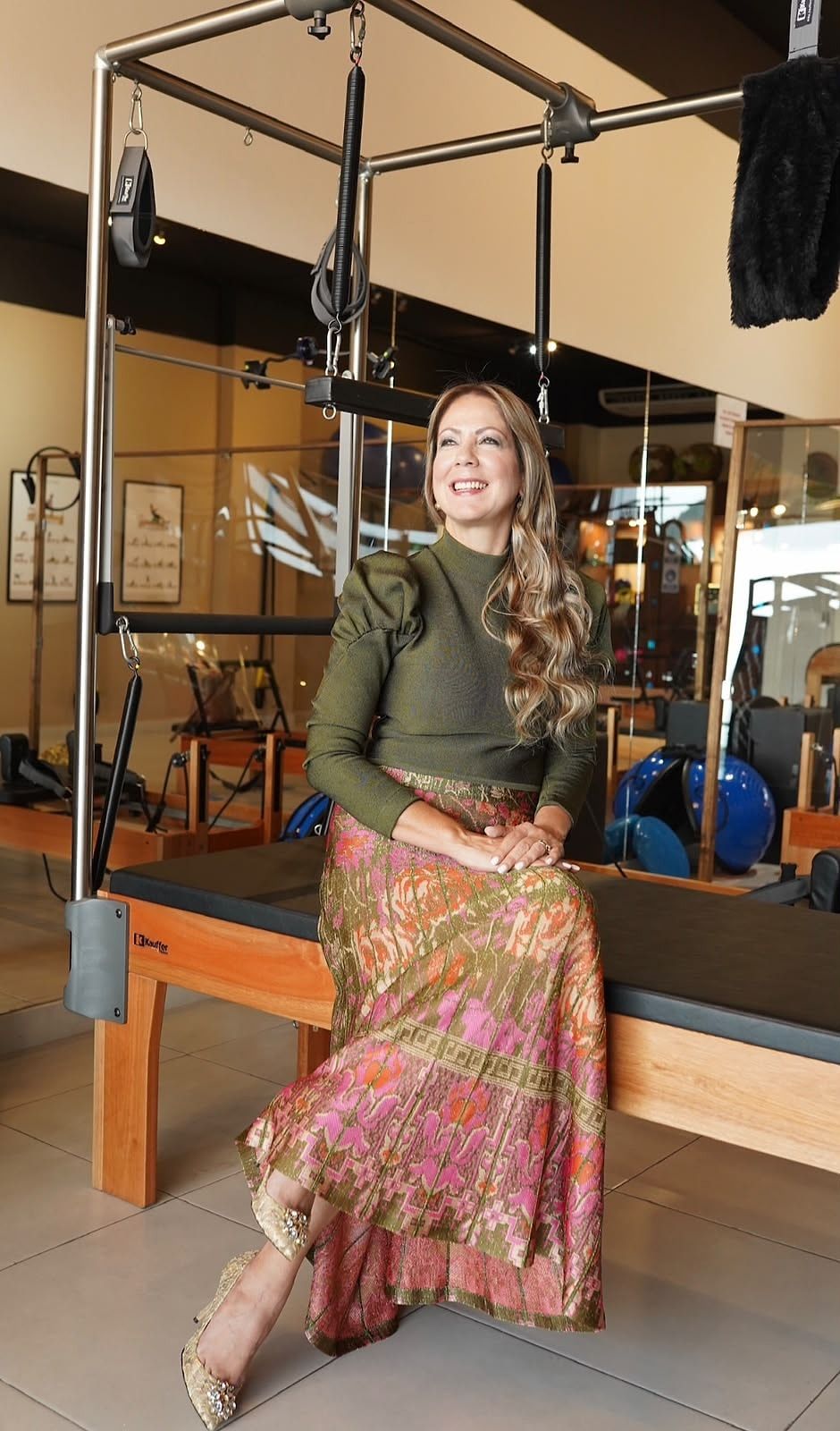 Luzmila de Arrue, fundadora del estudio, sentada y sonriente en una máquina Cadillac